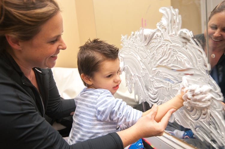 image0 boy playing with shaving cream on mirror with occupational therapist